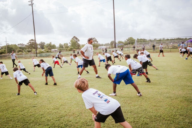Kids run drills at Patrick Queen 2022 "level Up" youth football camp