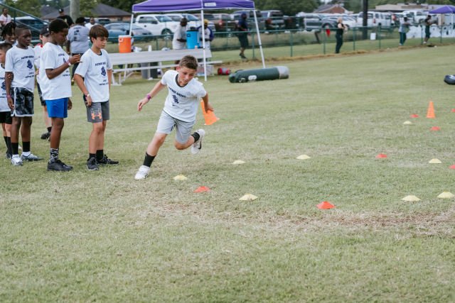 Kids run drills at Patrick Queen 2022 "level Up" youth football camp