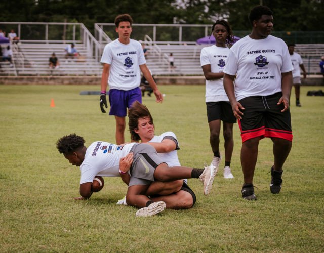 Kids run drills at Patrick Queen 2022 "level Up" youth football camp