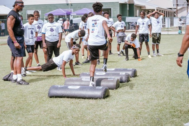 Kids run drills at Patrick Queen 2022 "level Up" youth football camp