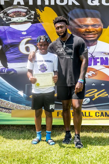 Patrick takes photos with one of the kids at Patrick Queen 2022 "level Up" youth football camp